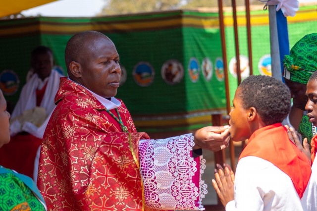 The new confirmed adolescent receives the Eucharist on tongue