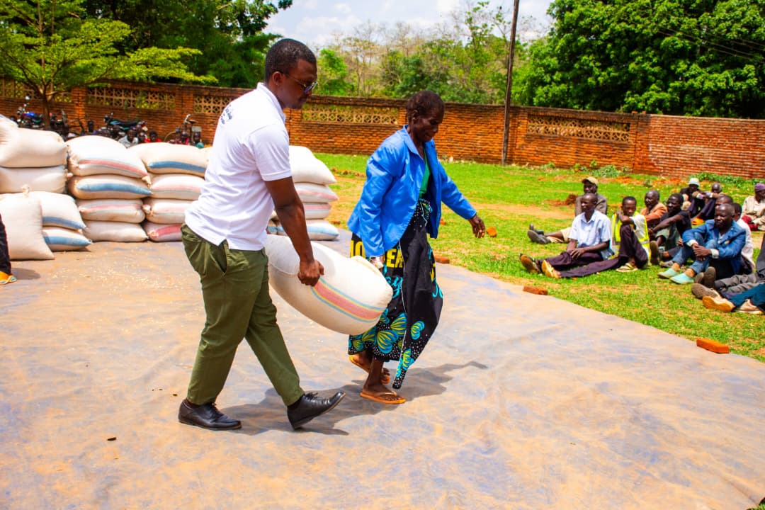 Odiambo, helps a woman carrying her bag